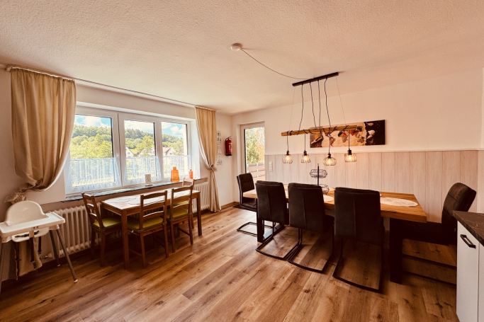 Großer Essbereich im Ferienhaus Taufstein mit zwei Tischgruppen und Platz für die ganze Gruppe